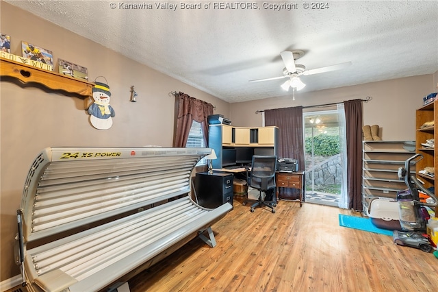 misc room featuring light hardwood / wood-style floors, a textured ceiling, and ceiling fan