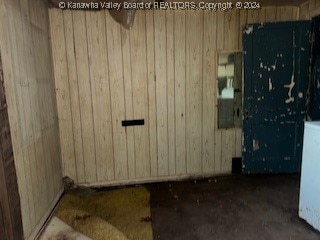 empty room featuring wood walls