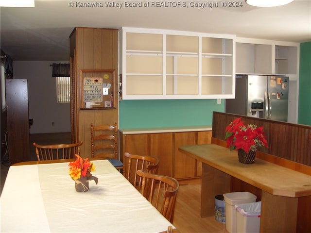 dining room featuring wood walls and light hardwood / wood-style flooring