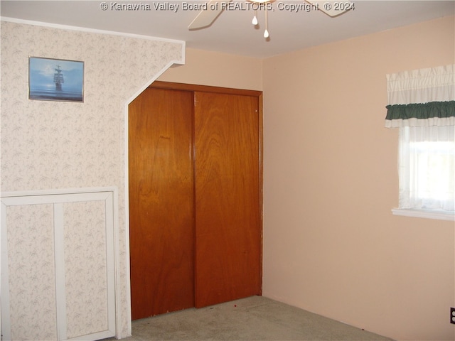 unfurnished bedroom with a closet, ceiling fan, and light colored carpet