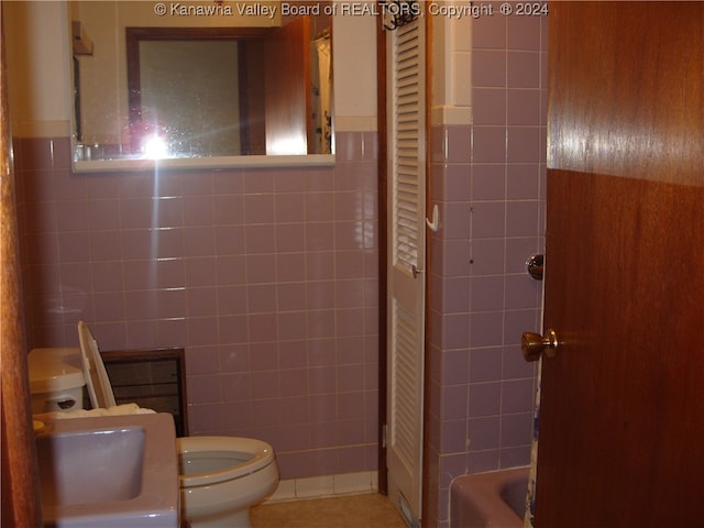 full bathroom with sink, toilet, tile walls, and shower / tub combo