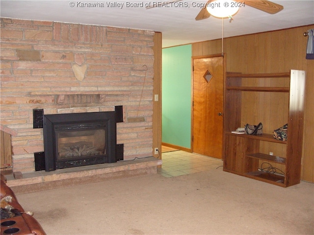 carpeted living room featuring wooden walls and ceiling fan