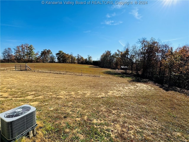 view of yard featuring a rural view and central air condition unit