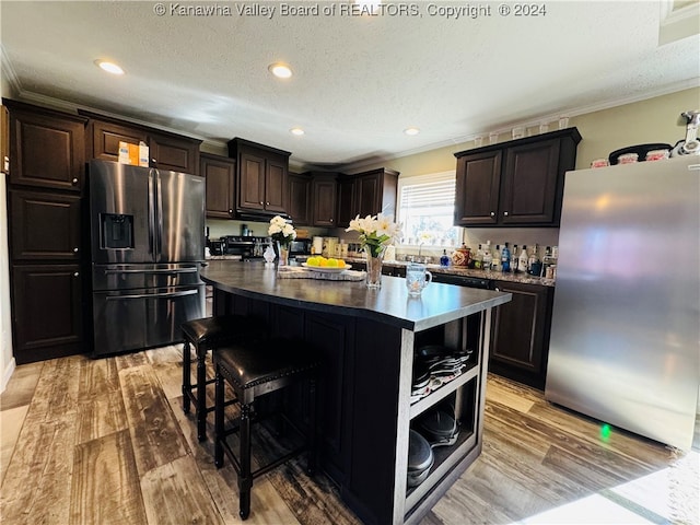 kitchen with stainless steel fridge, stainless steel fridge with ice dispenser, light hardwood / wood-style flooring, and a kitchen island