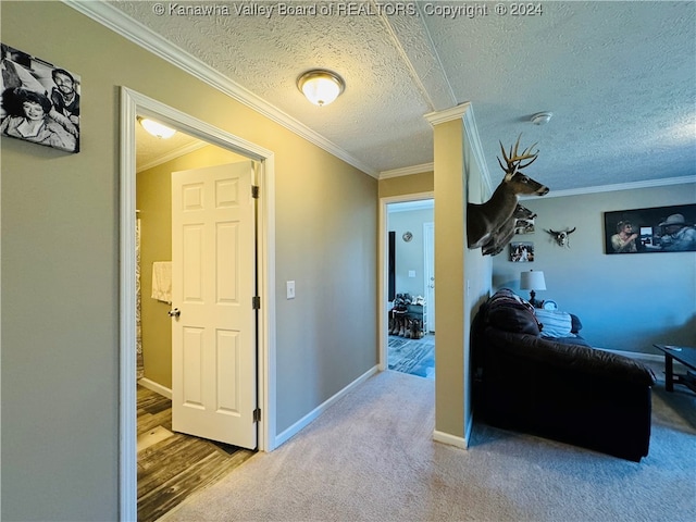 corridor featuring ornamental molding, a textured ceiling, and carpet flooring