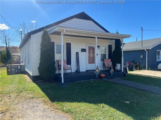 bungalow with covered porch and a front yard