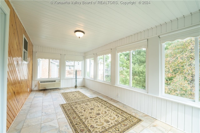 unfurnished sunroom with a wall mounted air conditioner