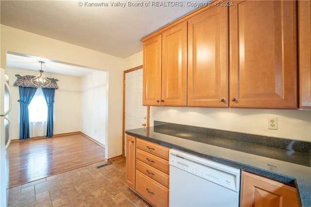 kitchen featuring a textured ceiling, hardwood / wood-style flooring, white dishwasher, and a notable chandelier