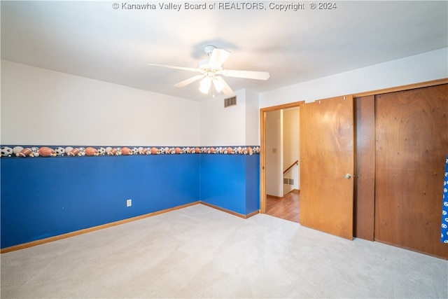 unfurnished room with light colored carpet and ceiling fan