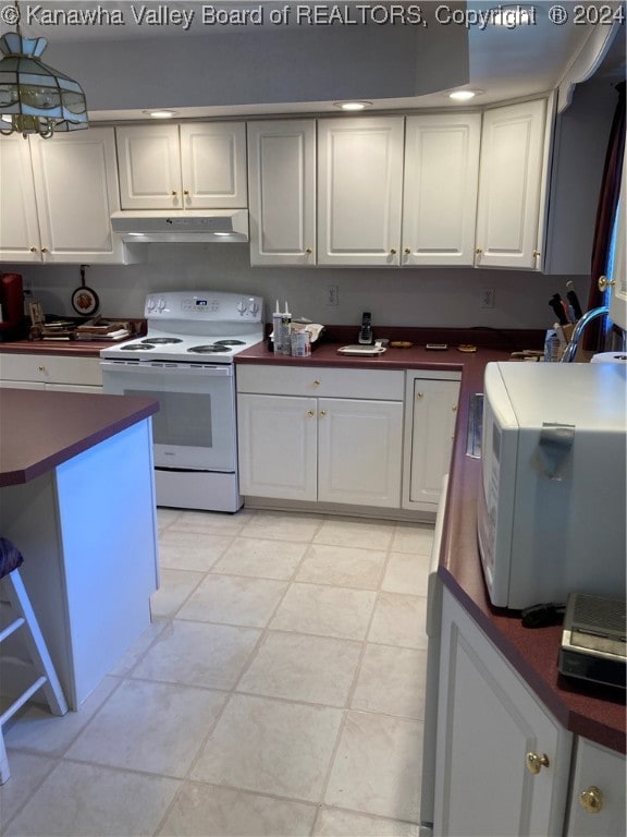 kitchen featuring white cabinets, hanging light fixtures, light tile patterned floors, and white appliances