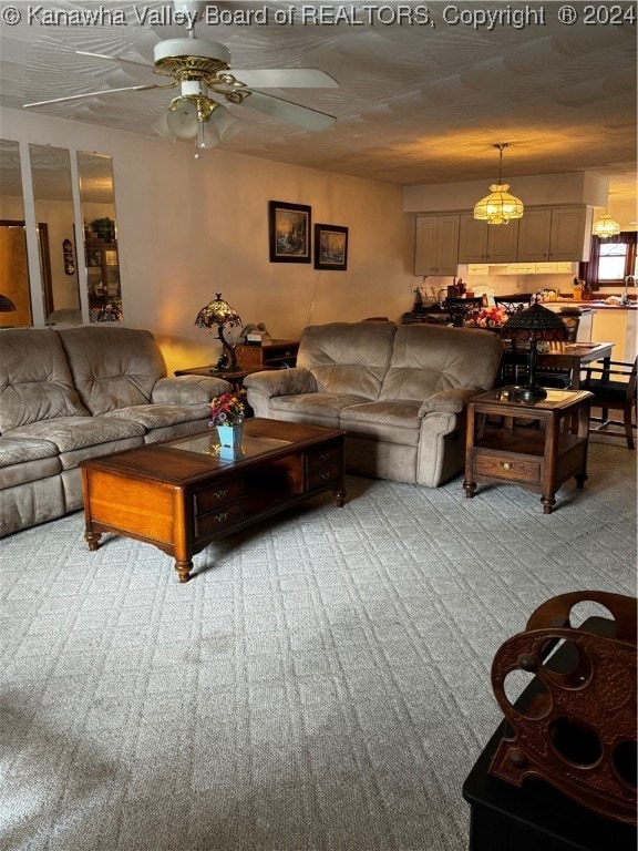 living room with ceiling fan and carpet