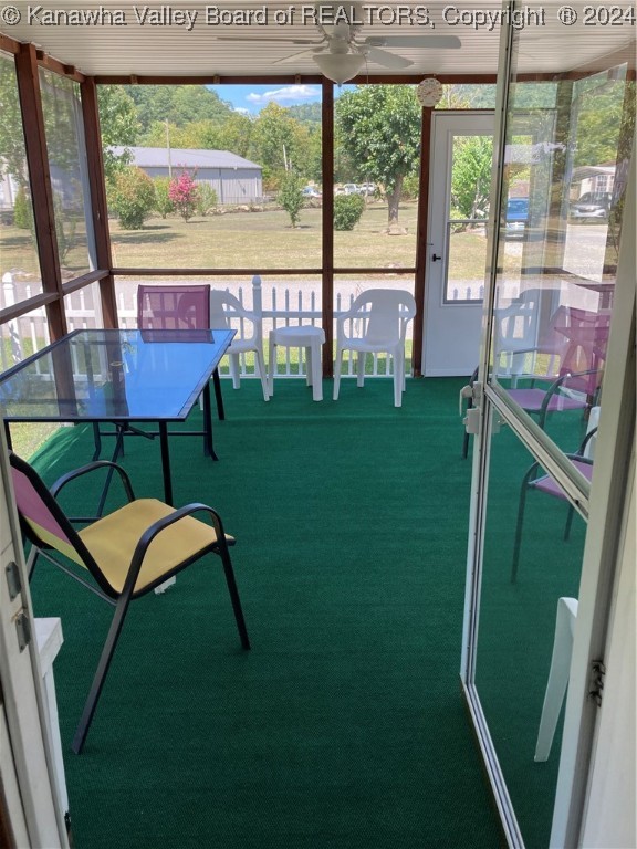 unfurnished sunroom featuring ceiling fan