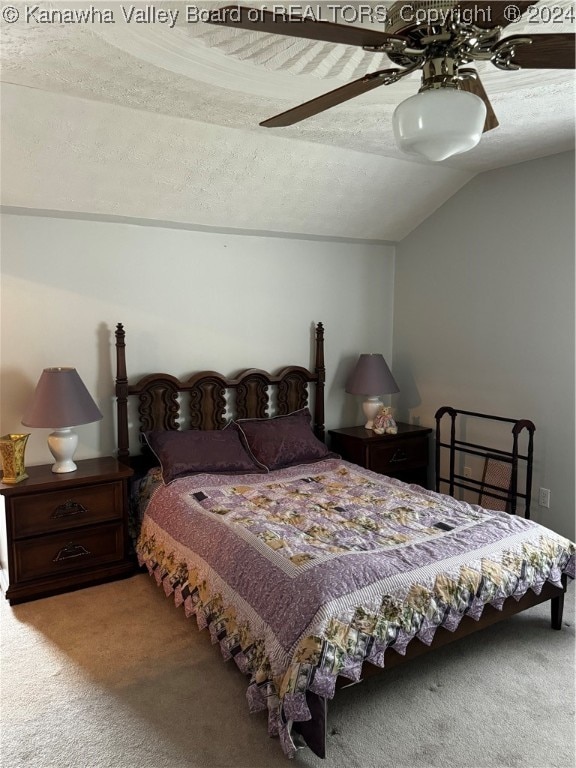 carpeted bedroom with lofted ceiling, a textured ceiling, and ceiling fan