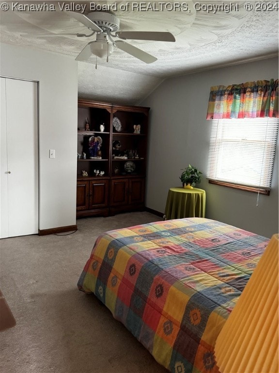 carpeted bedroom with ceiling fan, a textured ceiling, and lofted ceiling