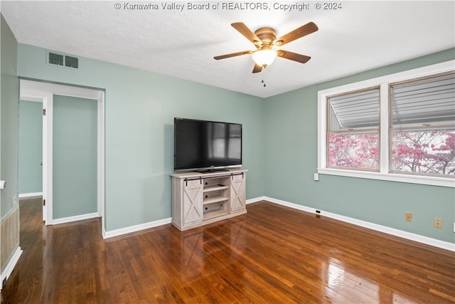 unfurnished living room with ceiling fan, a textured ceiling, and dark hardwood / wood-style flooring