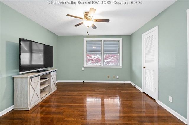 unfurnished living room featuring a textured ceiling, dark hardwood / wood-style flooring, and ceiling fan