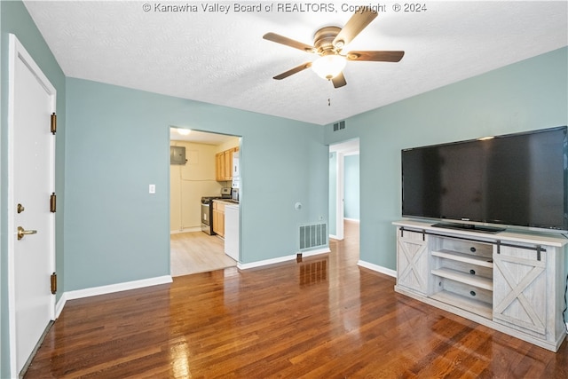 unfurnished living room with ceiling fan, a textured ceiling, and light hardwood / wood-style flooring