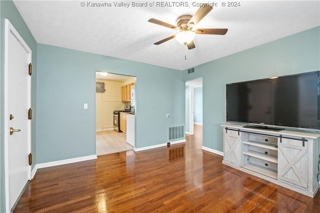 302 Kenna Dr, South Charleston, WV 25309 - unfurnished living room with wood finished floors, ceiling fan, and a textured ceiling