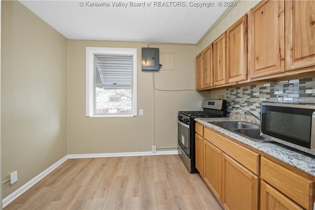 kitchen featuring electric panel, stainless steel appliances, backsplash, sink, and light hardwood / wood-style flooring