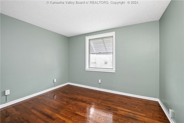 empty room featuring wood-type flooring and a textured ceiling