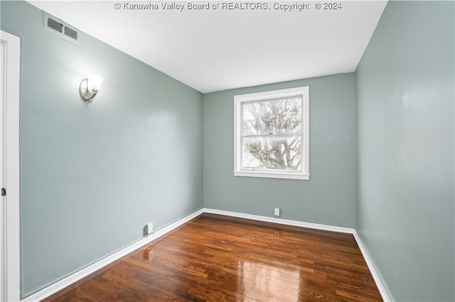 empty room with dark hardwood / wood-style flooring