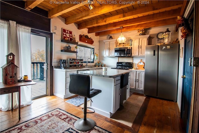 kitchen featuring stainless steel appliances, stone countertops, beamed ceiling, decorative light fixtures, and hardwood / wood-style floors