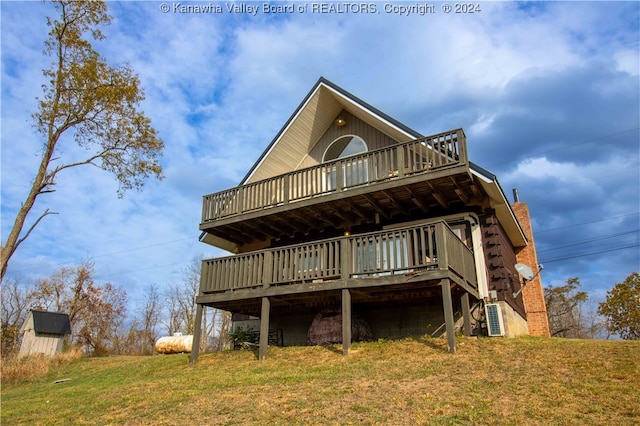 back of property featuring a wooden deck and a yard