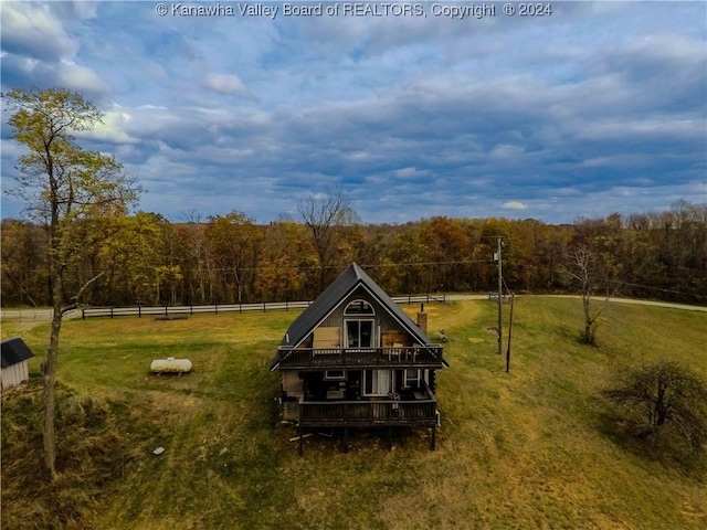 rear view of property featuring a porch, a yard, and a rural view