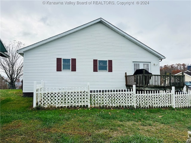 view of side of home featuring a yard and a deck