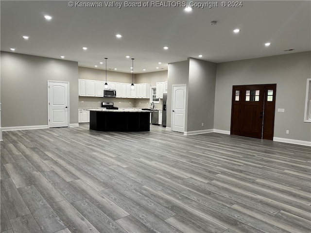 kitchen with light wood-type flooring, pendant lighting, and a kitchen island