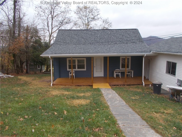 bungalow-style home with a front yard and covered porch