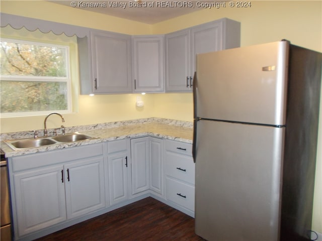 kitchen featuring white cabinets, sink, stainless steel fridge, and dark hardwood / wood-style floors