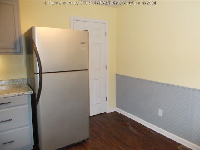 kitchen featuring dark wood-type flooring and stainless steel fridge