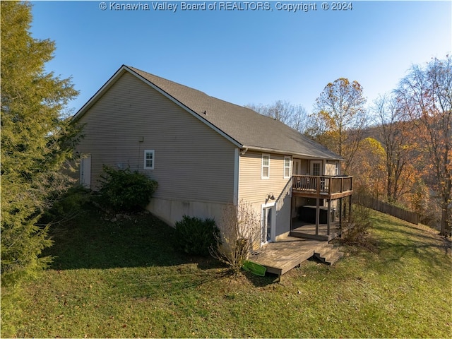 rear view of house with a lawn and a deck