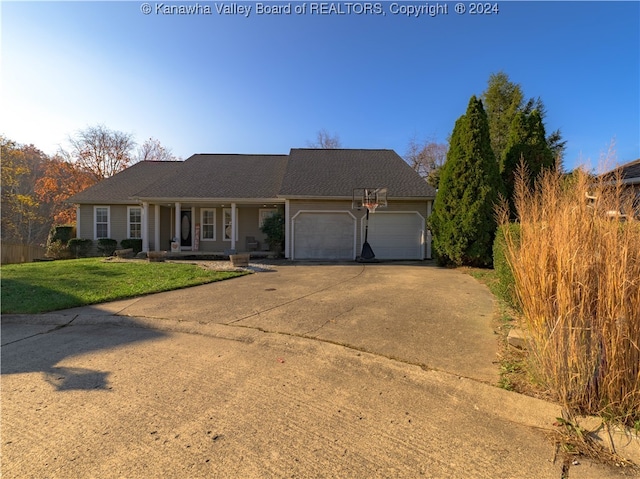 ranch-style house featuring a front lawn, a garage, and covered porch