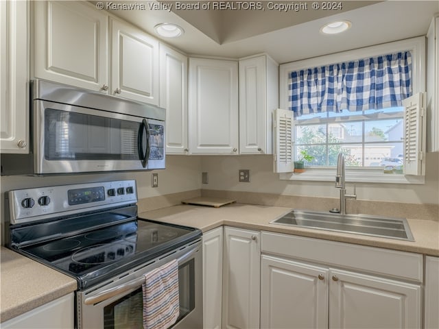 kitchen featuring stainless steel appliances, white cabinets, and sink