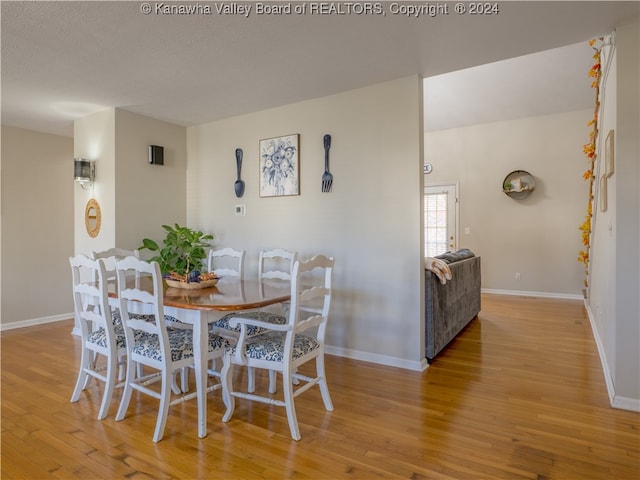 dining room with a textured ceiling and light hardwood / wood-style flooring