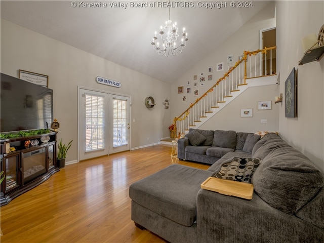 living room featuring high vaulted ceiling, hardwood / wood-style floors, and a chandelier