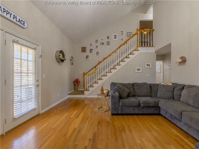 unfurnished living room with high vaulted ceiling and wood-type flooring