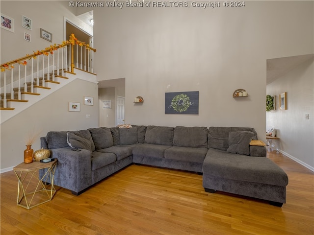 living room with a towering ceiling and wood-type flooring