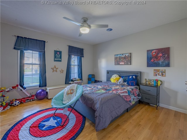 bedroom featuring ceiling fan, multiple windows, and light wood-type flooring