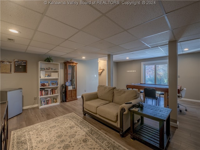 living room with a paneled ceiling and hardwood / wood-style floors