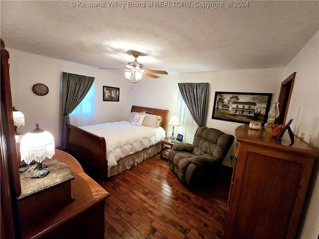 bedroom featuring ceiling fan, dark hardwood / wood-style flooring, and a textured ceiling