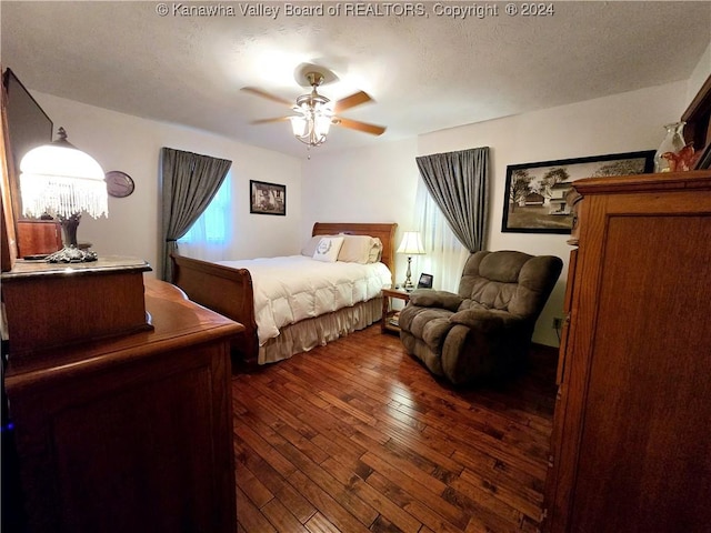 bedroom with ceiling fan, dark hardwood / wood-style floors, and a textured ceiling