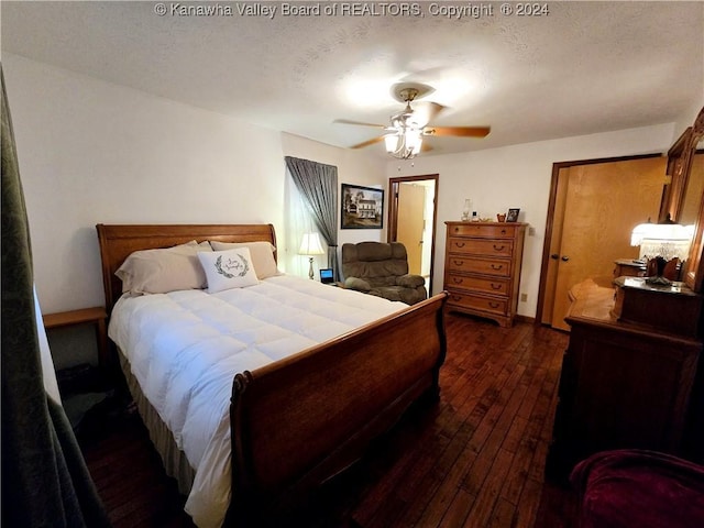 bedroom with dark wood-type flooring, a textured ceiling, and ceiling fan