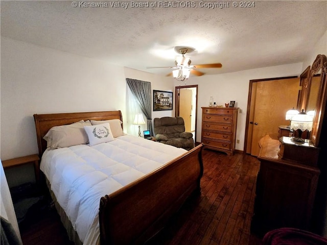 bedroom featuring dark wood-type flooring, a textured ceiling, and ceiling fan