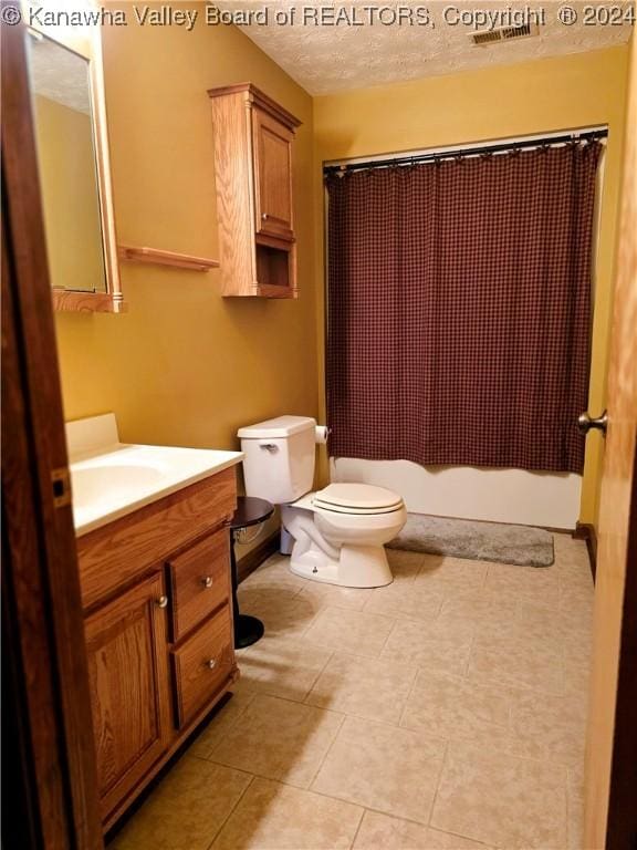 bathroom with vanity, toilet, tile patterned floors, a textured ceiling, and a shower with curtain