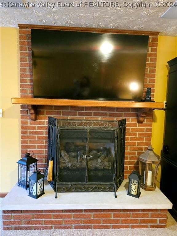 interior details featuring a brick fireplace and a textured ceiling