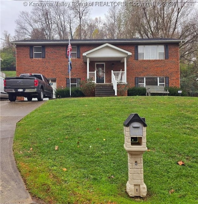 bi-level home with a porch and a front lawn