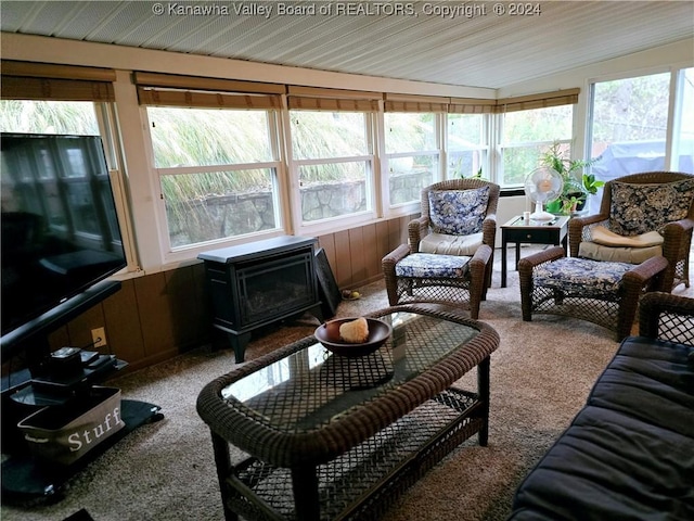 sunroom / solarium with vaulted ceiling and a wood stove